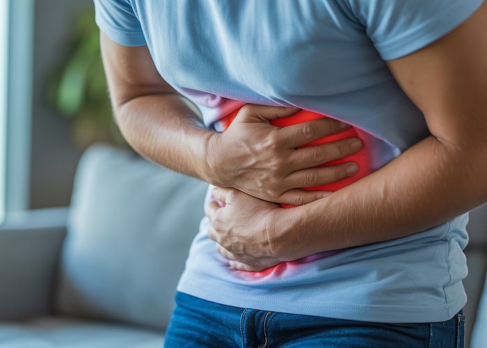 Person experiencing severe stomach pain, a common symptom of alcohol gastritis.