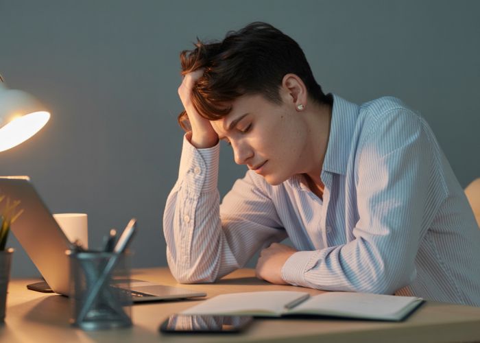 Person feeling sleepy while working at a desk, illustrating drowsiness.