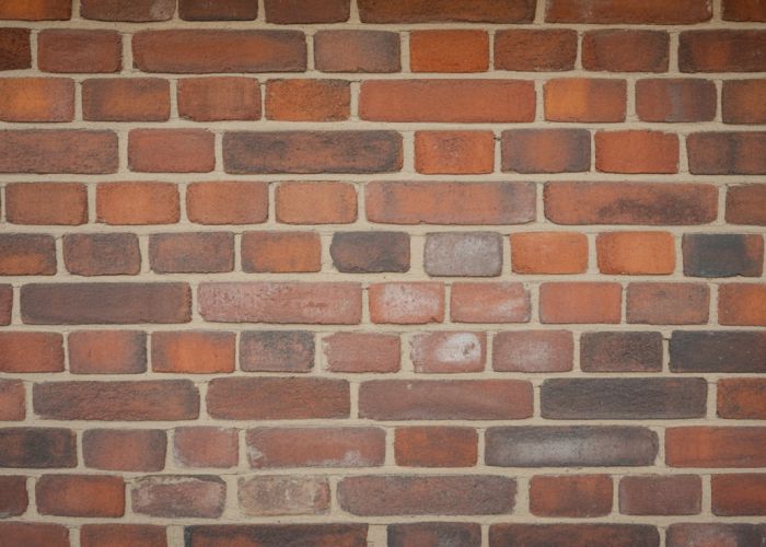 Close-up of a weathered brick wall showing signs of age and demonstrating the bricks' durability.