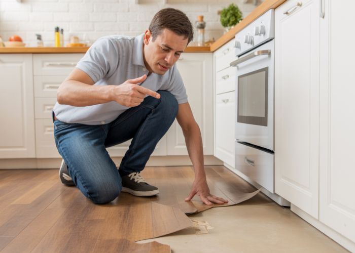 Damaged vinyl flooring with bubbles and peeling.