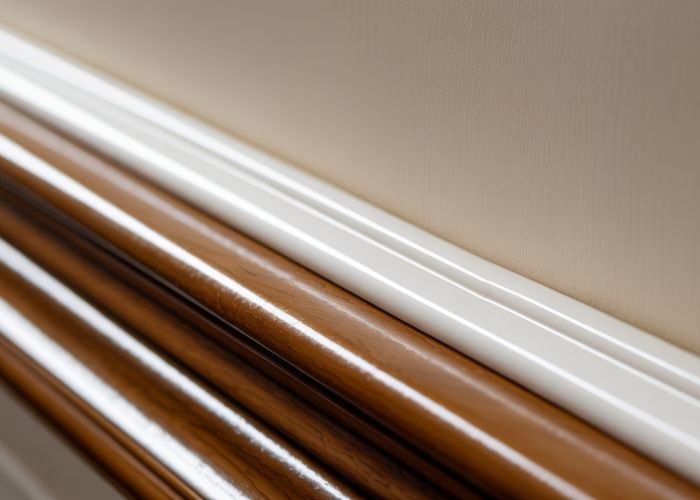 Perfectly caulked wood trim detail showing a smooth, white sealant filling the gap between the trim and the wall.