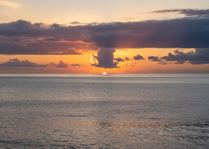 Sunset over the Kona coast in Hawaii, reflecting the peaceful meaning of 'Kona'.