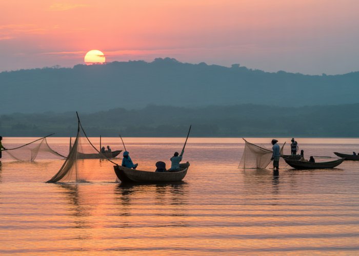 Sunrise over Lake Victoria, Uganda, with traditional fishing boats.