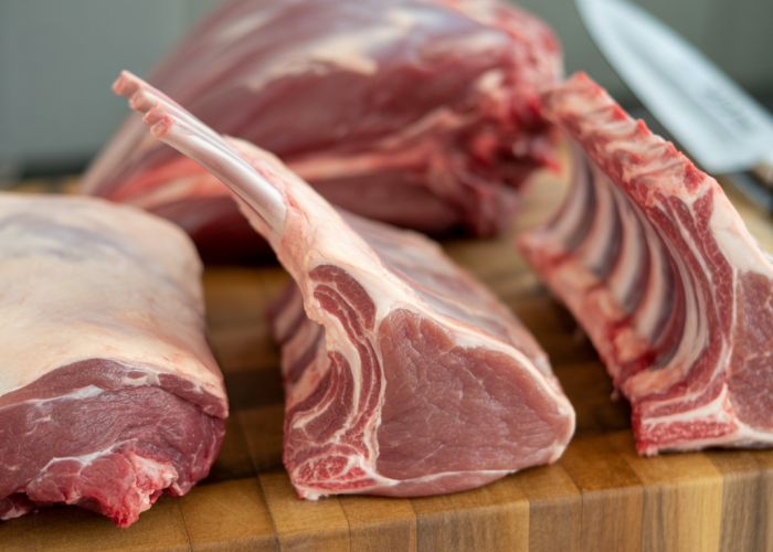Variety of raw lamb primal cuts including leg, rack, loin, and shoulder.