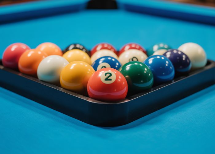 Perfectly racked set of pool balls on a blue felt pool table, ready for the break.