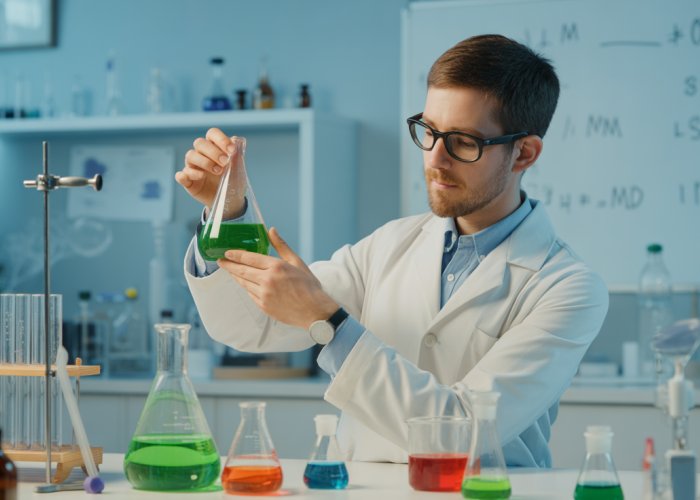Chemist converting ppm to molarity in a laboratory setting, with example calculations on a whiteboard.