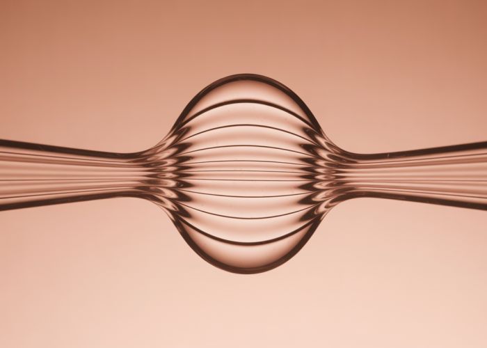Close-up of a stretched rubber band showing visible stress lines.