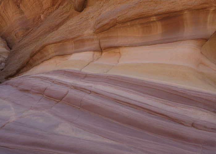 Banded layers of sedimentary rock formation in a desert canyon wall.