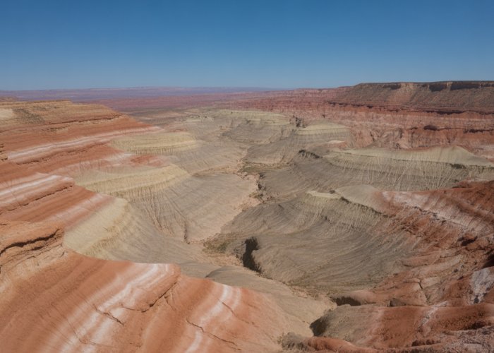 Layered sedimentary rock formations in a canyon demonstrate the process of rock deposition over time.