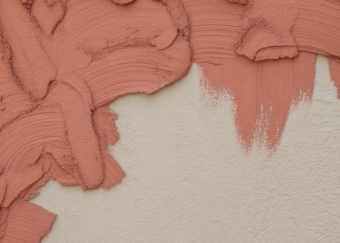 Textured stucco applied over painted wall, showing a before and after transformation.